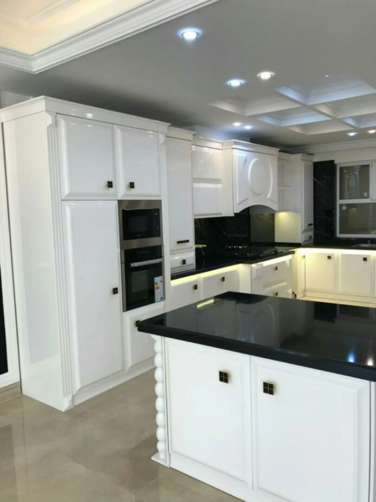 کابینت و جزیره انزوی سفید با صفحه کابینت مشکی و دستگیره مربعی