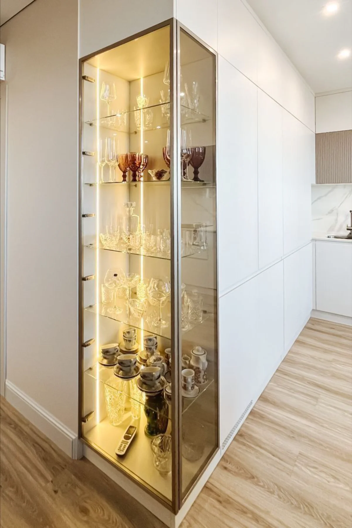 ویترین کابینت مدرن بدون دستگیره اجرا شده در ورودی آشپزخانه و دارای دو درب شیشهای در زاویه ال شکل