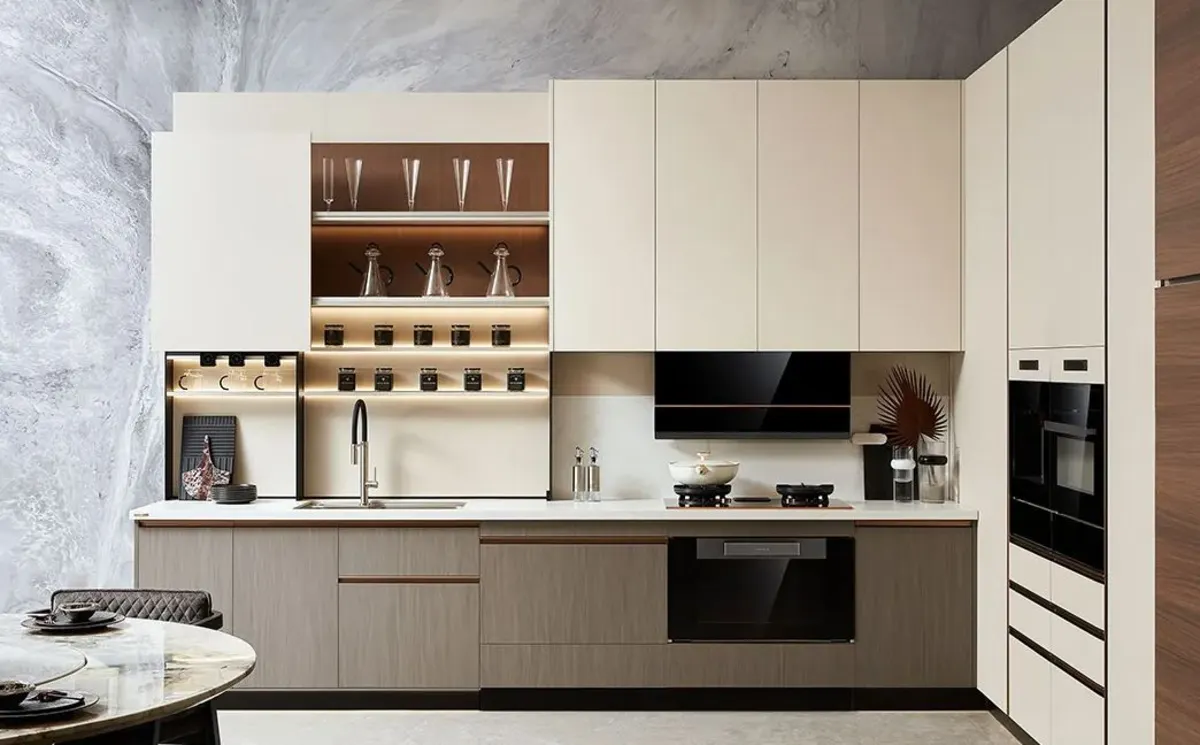 کابینت مدرن کرم و نسکافهای با ویترین بالای سینک و دکوریها و ظروف شیشهای داخل آن با نور پزدازی خطی