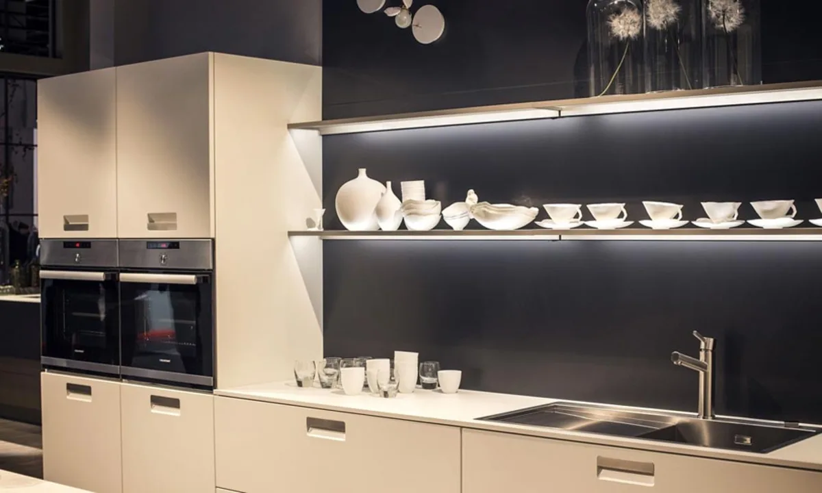 دو طبقه ویترین باز کابینت مدرن با نورپردازی زیر طبقات و کابینت کمدی کنار آن با فر توکار اجرا شده در آن