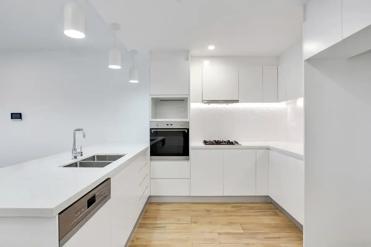 کابینت‌های سفید مدرن بدون دستگیره با نور مخفی زیر کابینتی